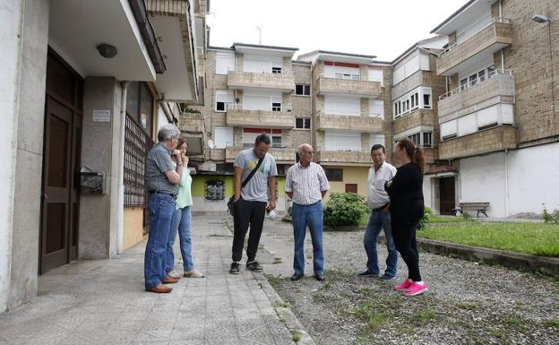 Vecinos de Barreda junto a los bloques de 24 viviendas que aún tienen pozos negros