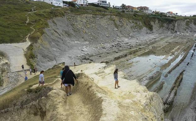 El islote de la playa de La Arnía está cada vez más pelado de vegetación.
