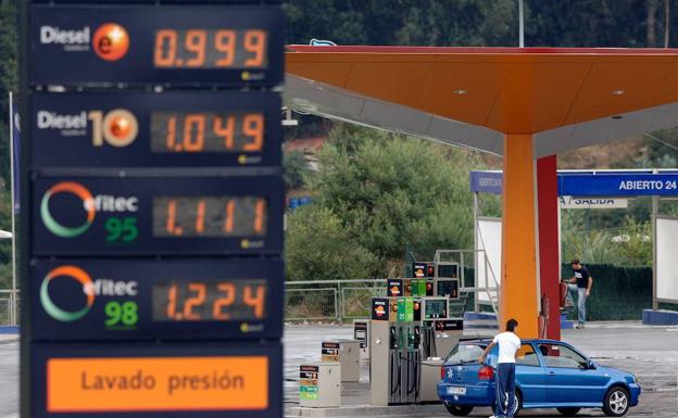 Cartel con los precios del combustible, ante una gasolinera.