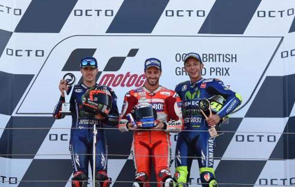 Andrea Dovizioso (c), entre Maverick Viñales (i) y Valentino Rossi, en el podio de Silverstone.
