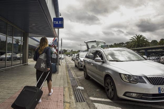 Varios viajeros, en la parada de taxis del aeropuerto Seve Ballesteros. /Javier Cotera