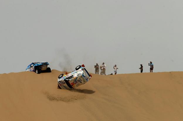Cristina Gutierrez y Gabriel Moiset Ferrer, del equipo Mitsubishi, sufren un percance en las dunas. :: reuters/