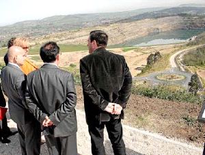 Del Olmo y los alcaldes observan el trazado del carril-bici, con el lago al fondo. / DM/