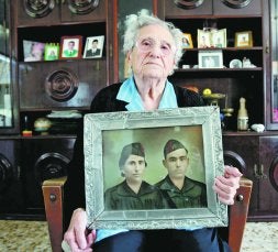 María de la Luz Mejías Correa, el pasado 17 de marzo, con un retrato en el que aparece junto a su marido, el también miliciano Juan Mendoza Casado. / CASIMIRO MORENO/