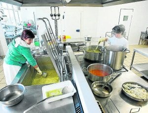 Dos cocineras preparan la cocina en la marmita y en la placa radiante./