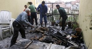 Los vecinos de la vivienda incendiada en Selaya retiran los escombros. :: SANE/